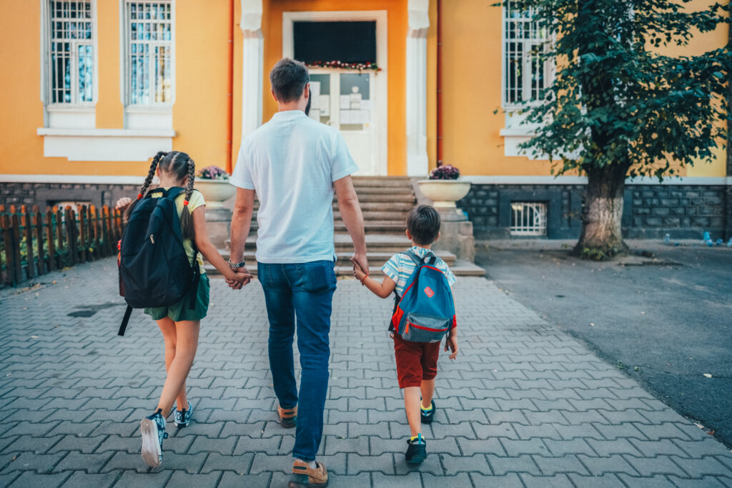 Father taking his daughter and son to school